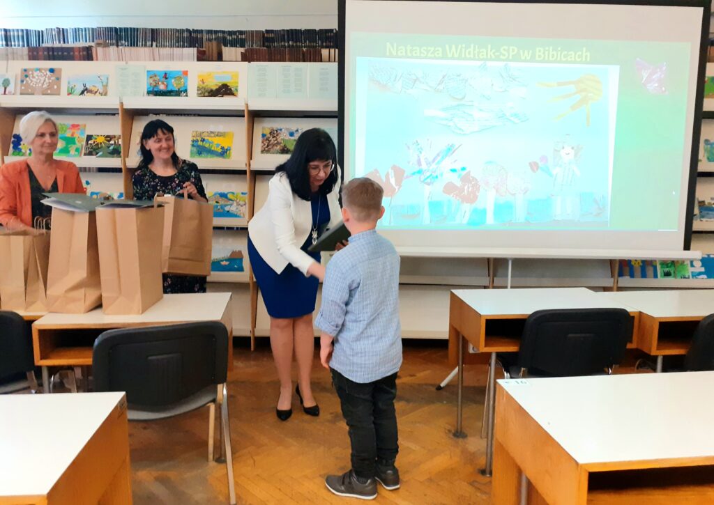 Pani Dyrektor Biblioteki Anna Piotrowska gratuluje chłopcu zajęcia I miejsca w konkursie.