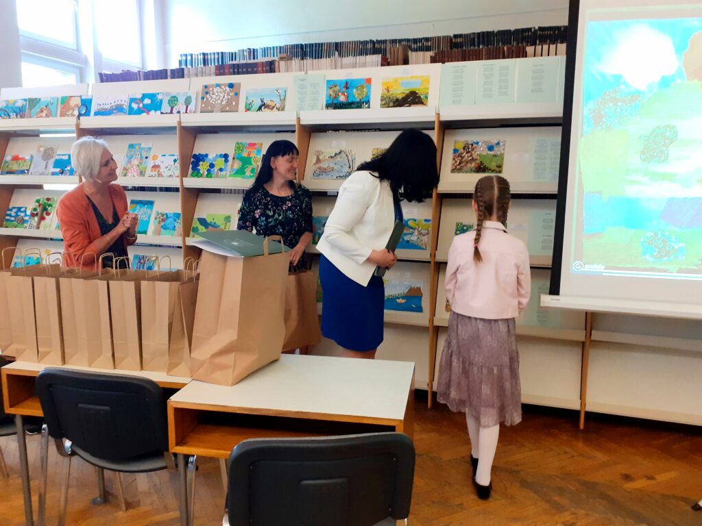 Pani Dyrektor i 2 nauczycielki wraz z dziewczyną, która zajęła II miejsce w konkursie oglądają wystawę prac.